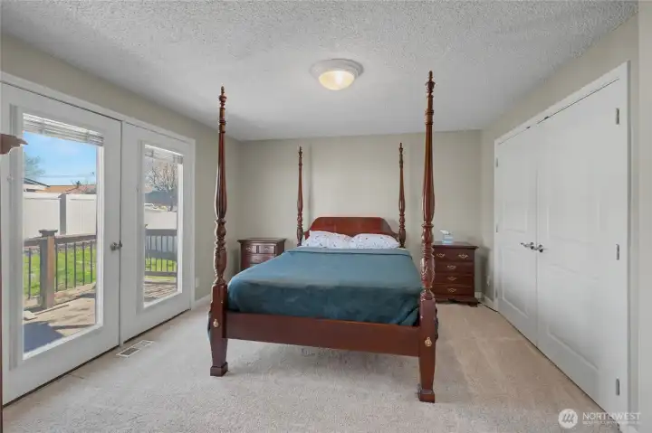 Primary bedroom and French doors to deck and pool area in back yard