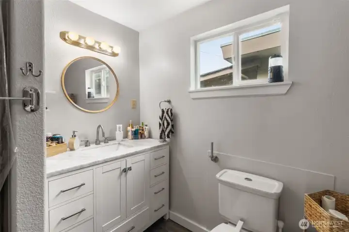 Full bath centrally located with direct access from the bedroom for added convenience, large countertop and ample storage.