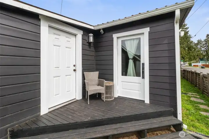 The back porch provides easy access to a storage area and the basement below as well as the back yard.