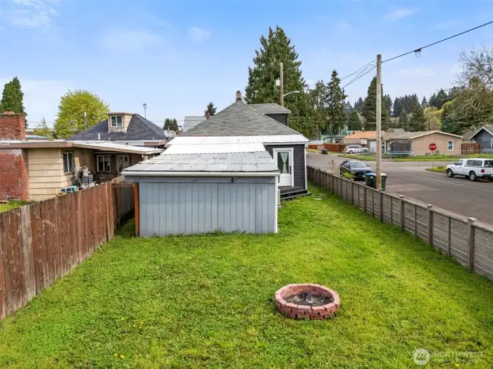 Former carport with attached storage offers potential for workshop or covered outdoor living area.