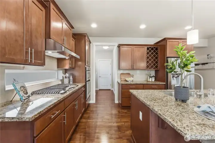 Kitchen view showing the convenient garage entry and the walk-in pantry located to the left, just beyond the wall ovens