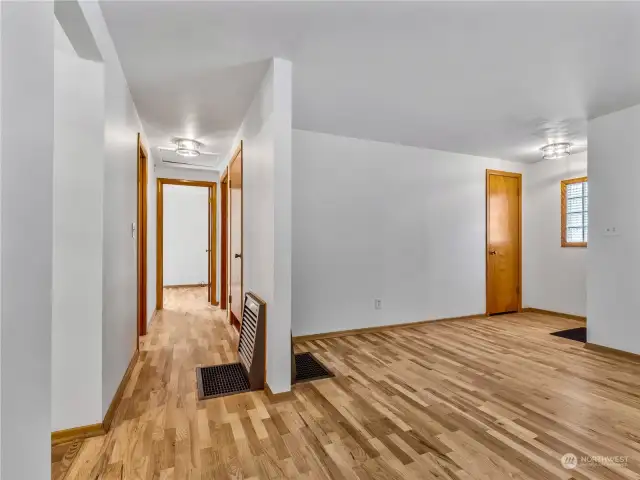 Down the hallway, find 2 bedrooms, bathroom, and access to the basement