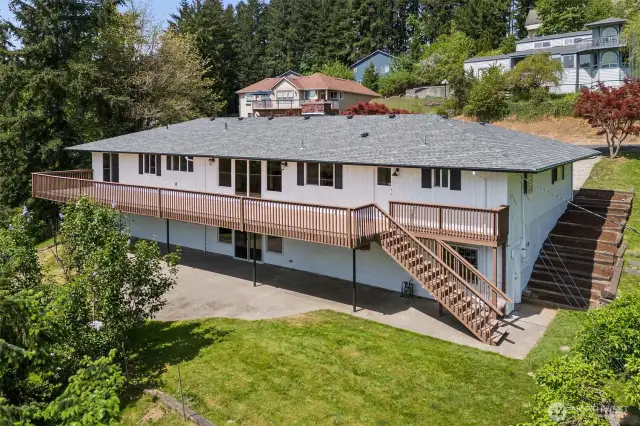 West side of home with expansive deck and daylight basement.