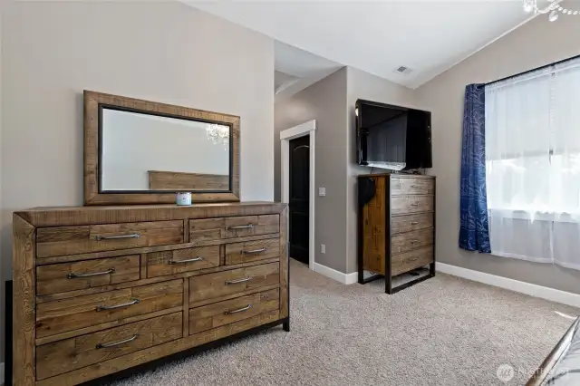 Primary bedroom, looking to hallway to 5 piece en-suite bath. Walk-in closet and laundry room on opposing walls.