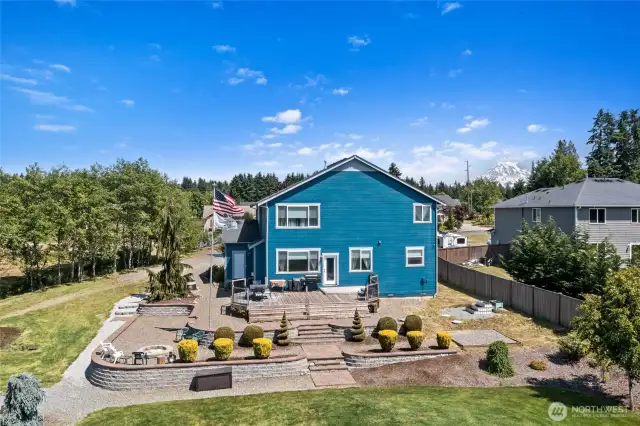 Terraced back deck leading to expansive lawn.