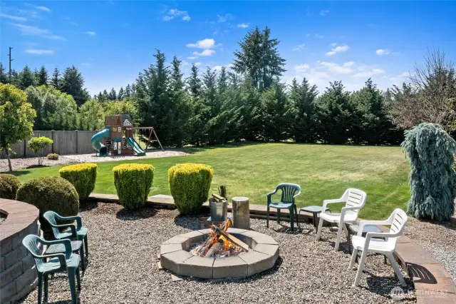 Large fire pit with ample seating beneath the flagpole.