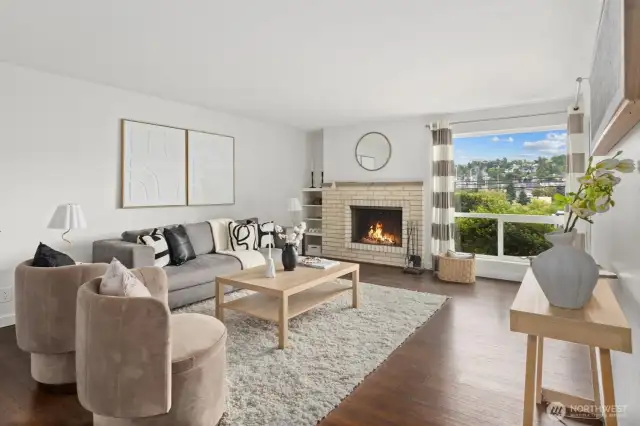 Living room with woodburning fireplace and territorial views over Interbay Golf Course and Queen Anne Hill.