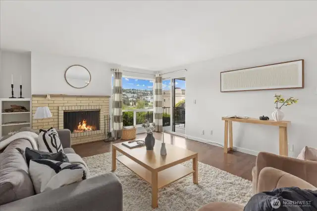 Living room with woodburning fireplace and territorial views over Interbay Golf Course and Queen Anne Hill.