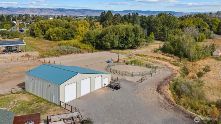 Overview of the shop with the arena and round pen and a large pastrure area to the right.