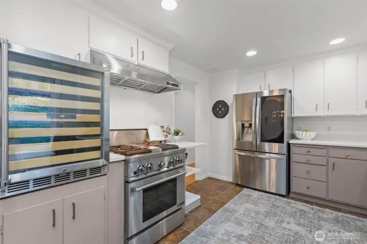 Enjoy the chef’s kitchen with a gas range, quartz countertops, and a wine fridge.