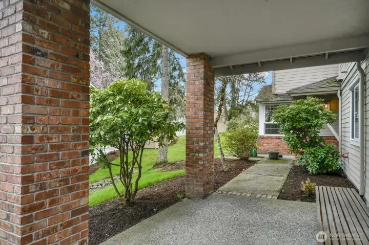 Gracious covered walkway from the street and the large green space to the side offer a peaceful, private approach.
