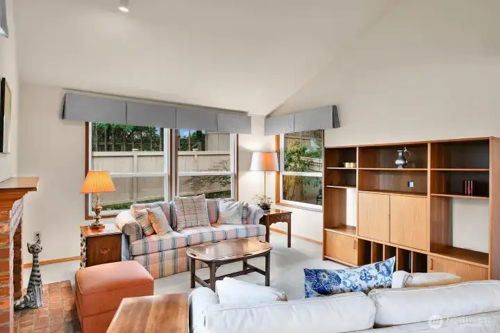 Gracious living room is filled with natural light by an abundance of new windows, high, vaulted ceiling, and accented with a brick-faced gas fireplace. No more hauling wood or cleaning ashes!