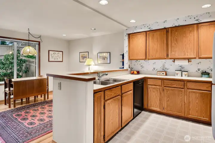 Open kitchen includes refrigerator, Bosch dishwasher, GE glass-top stove, Samsung microwave