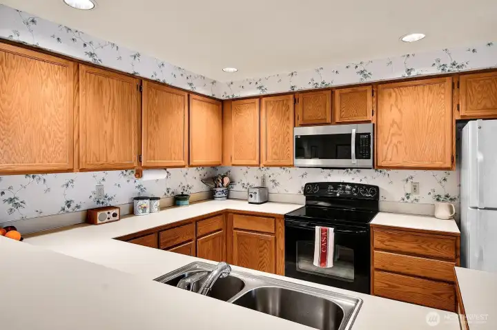 Here’s another view of the kitchen, showing its stainless sink with salad sink. Ample cabinetry and countertops make two-cook cooking an easy and pleasurable experience.