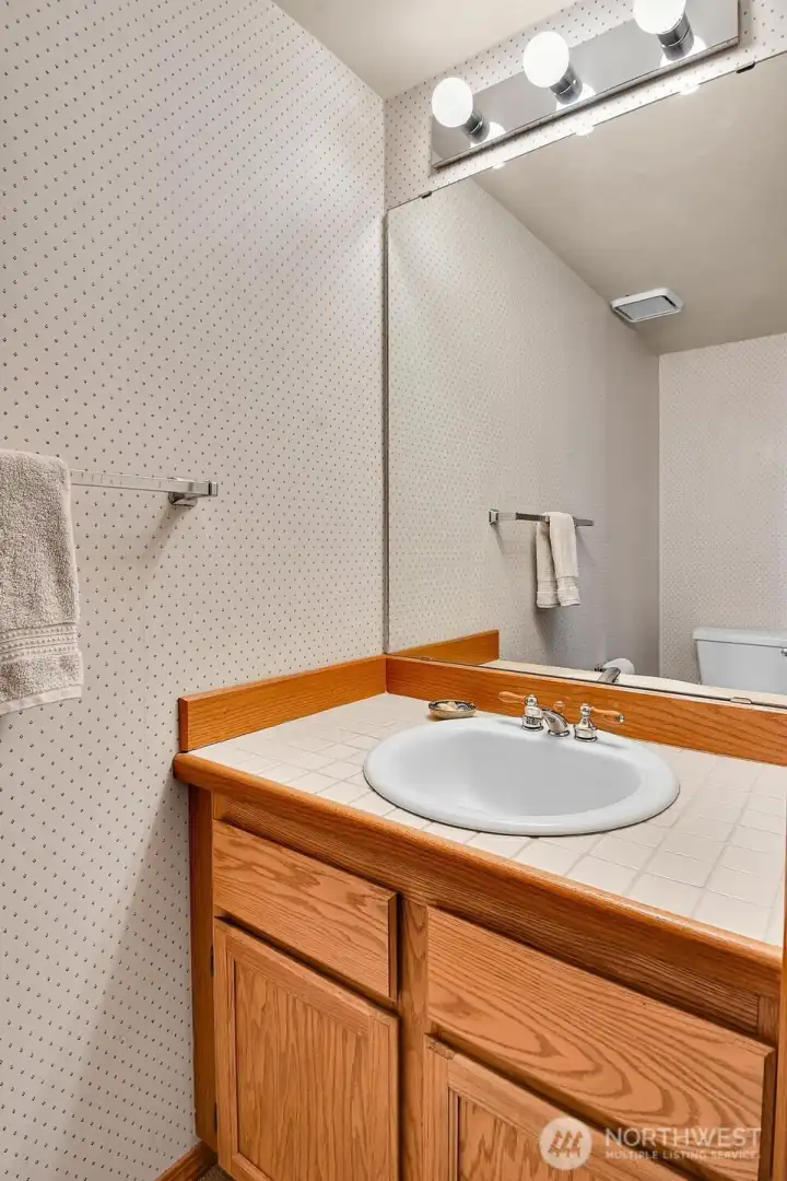 Convenient powder room is located off the entry hall. Hall coat closet gives additional under-the-stairs storage space.