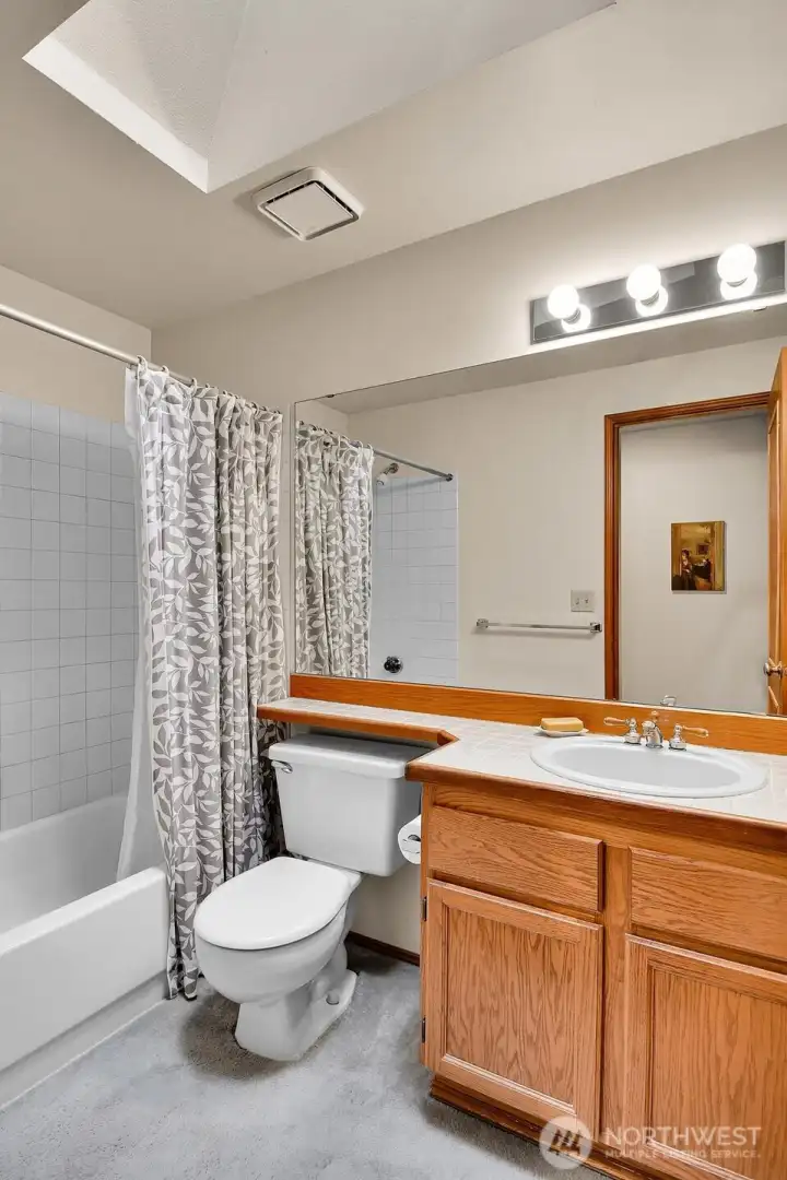 Both secondary upstairs bedrooms share this lovely full bath with skylight and spacious storage cabinets. There’s also a linen closet in the hallway right outside the door.