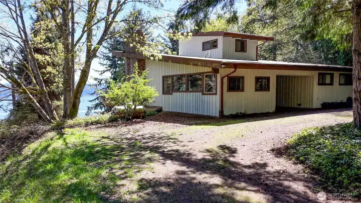 A look at the entrance to the home that has a large covered entryway. The belvedere,room perched atop athe main level offers privacy and stunning views overlooking the pristine waters of Hood Canal! A circular driveway offers plenty of parking spaces.