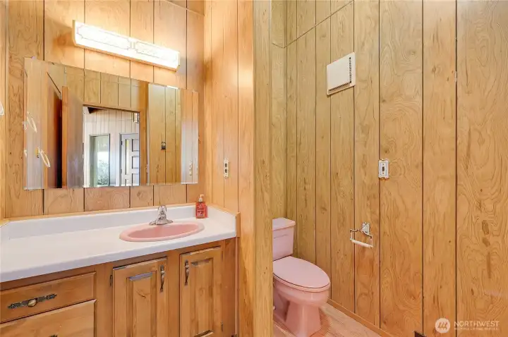 The powder room has two entrances - one near the main front door, and one conveniently located behind the kitchen storage wall.
