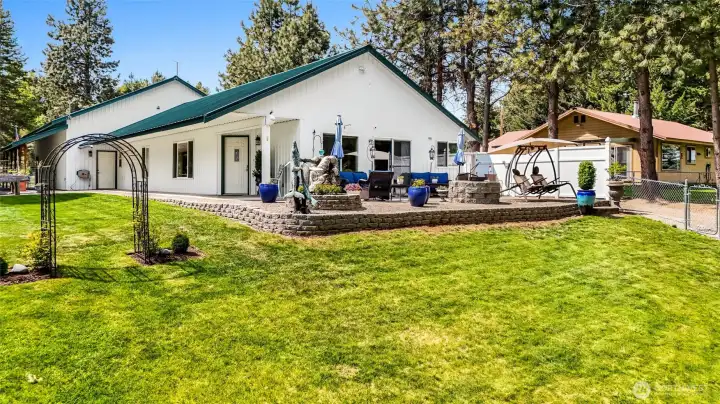 Rear exterior of home with patio and large fenced lawn