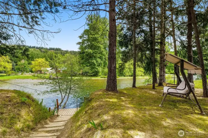 Riverfront view with dock under mature trees