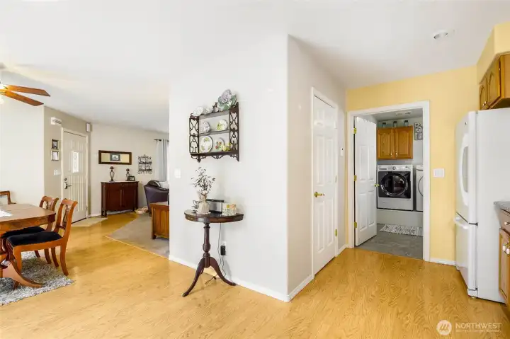 Dining area with wood flooring and open flow to living room and laundry room