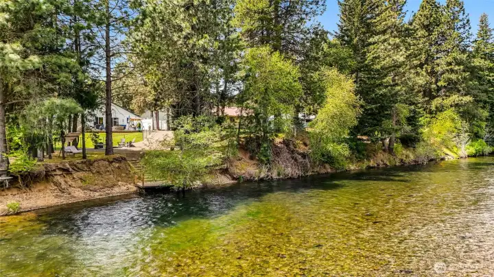 Riverfront view with clear water and tree-lined shoreline