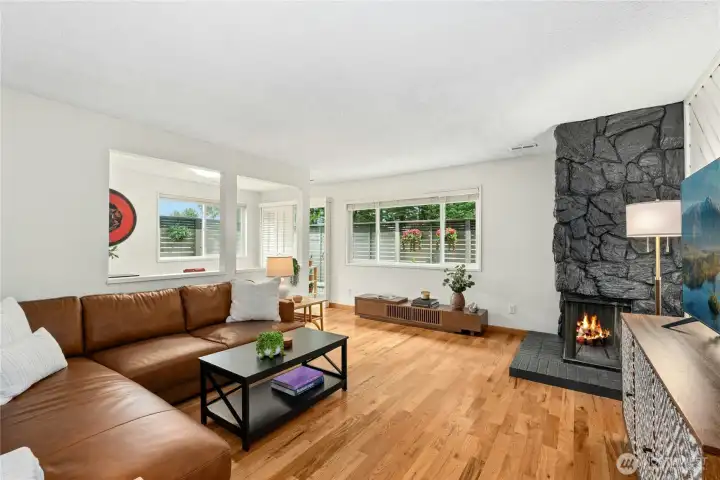 Living room with view to outdoor patio and pass-through opening to dining room | Wood burning fireplace | Fresh interior and fireplace paint
