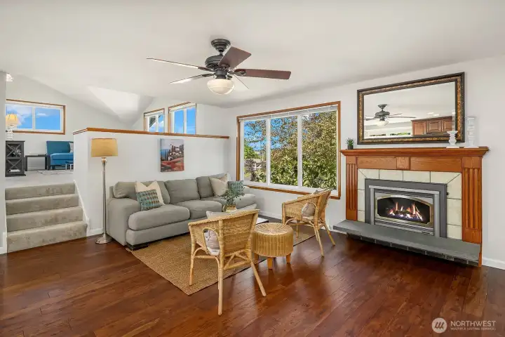 Triple-pane windows bring natural light into the living room, while the gas fireplace insert creates a warm and inviting focal point.