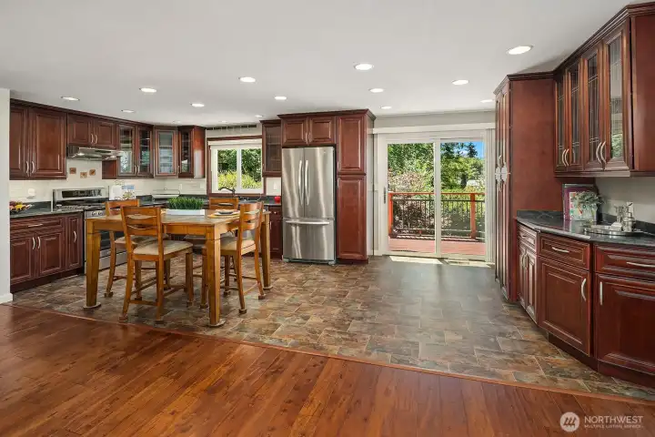 The updated kitchen combines extensive cherry cabinetry, stainless-steel appliances, recessed lighting, and direct access to the backyard deck.