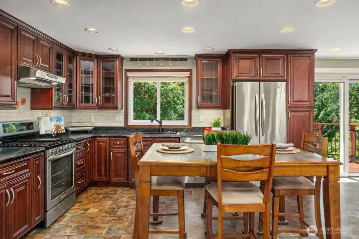 A spacious eat-in kitchen offers abundant cabinetry, stainless-steel appliances, generous preparation space, and room to gather.