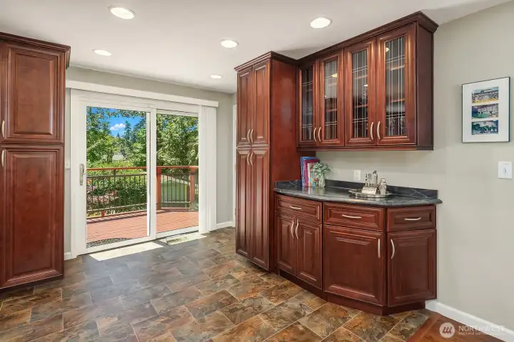 Additional built-in cabinetry creates valuable pantry, serving, and beverage space beside the sliding doors leading outdoors.