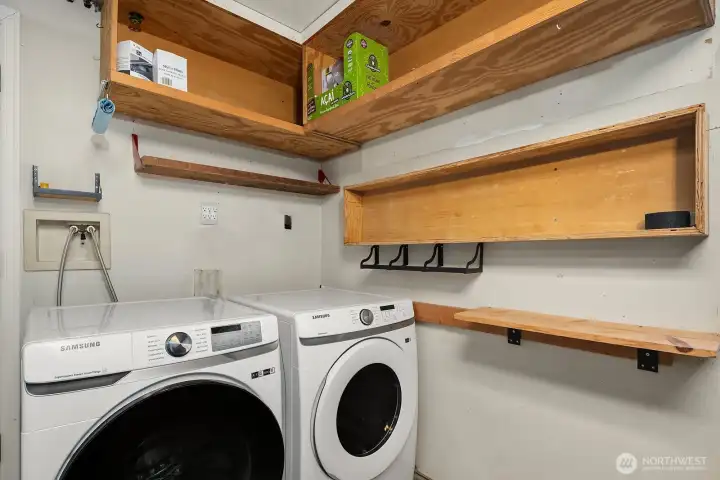 A dedicated laundry room with extensive built-in shelving and practical storage space for household supplies and everyday organization.
