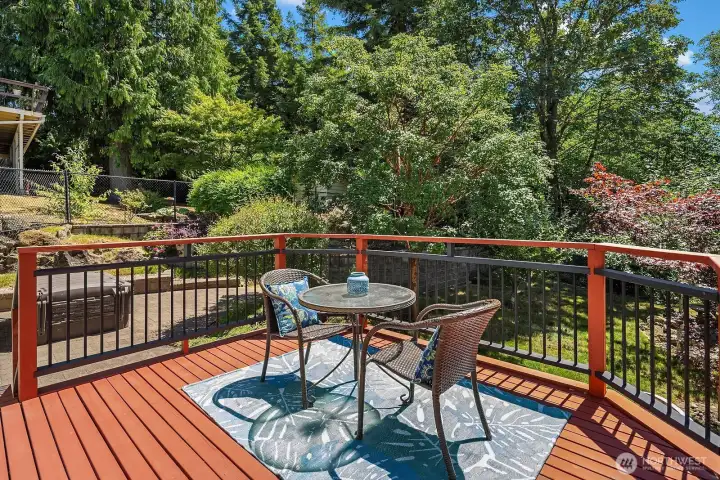 Overlooking the terraced backyard, this inviting deck provides a peaceful place to take in the mature landscaping and surrounding greenery.