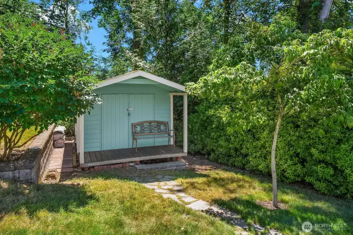 The detached shed is wired with electricity, making it ideal for a workshop, hobby space, garden equipment, or additional organized storage.