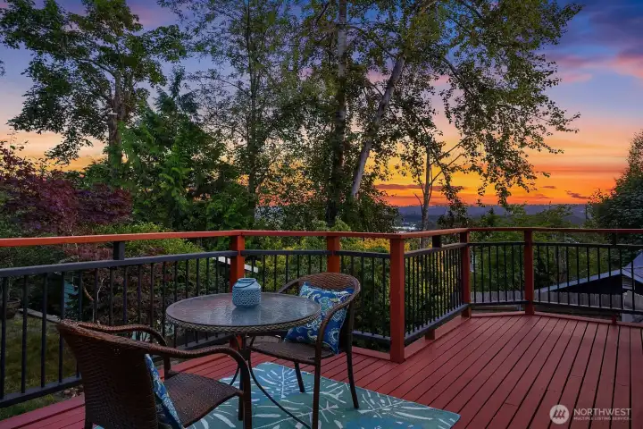 The spacious backyard deck becomes an especially inviting place at sunset, overlooking mature trees and the distant horizon.