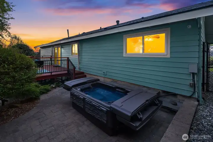 The professionally painted exterior, elevated deck, triple-pane windows, and paver patio come together in this peaceful twilight setting.