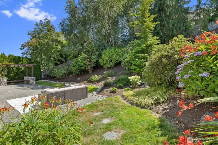 The backyard is your personal oasis! Such beautiful established gardens with flowering perennials and shrubs with in-ground automatic sprinkler system!