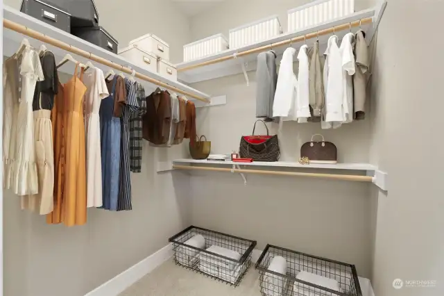 Walk-in closet on one side of the aisle and wardrobe on the other.