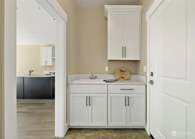 Utility room cabinets and sink with washer dryer space on other side