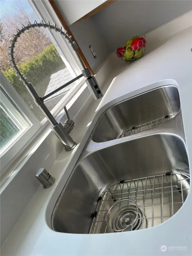 New double sink and quality pull-down faucet.  Removeable stainless steel grids help prevent chipping of dishes or sink.