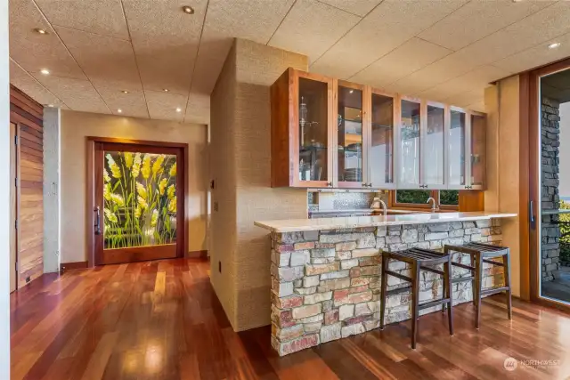 Approaching kitchen off dining.  Slight peek of the door to the left is walk in pantry.  Pronounced floral, pivot door leads to the tower section of the home.