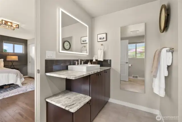 Back lit mirror quartz counters and designer tiles continue in the classic fashion of this house.