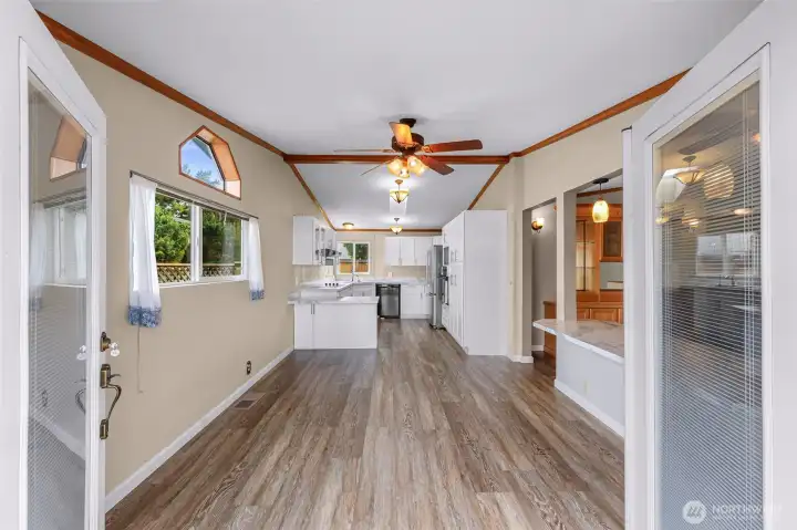 Entering through the French doors into flex space, kitchen and dining area