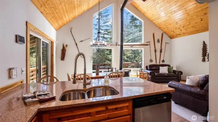 Floor-to-ceiling windows with vaulted ceilings create a bright and airy atmosphere in the Great room