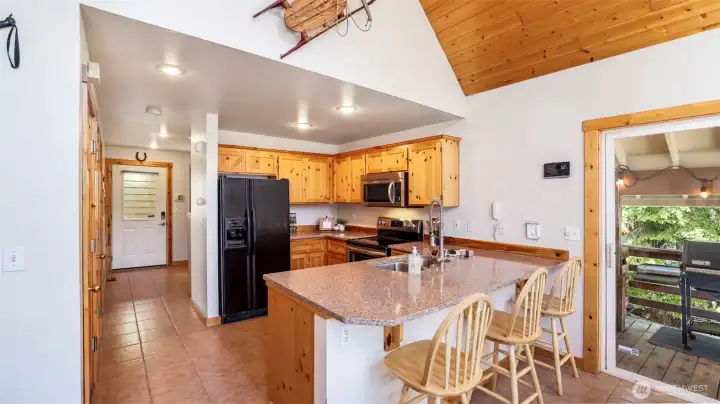 Knotty pine kitchen cabinets and newer quartz countertops bring warmth and charm to the space.