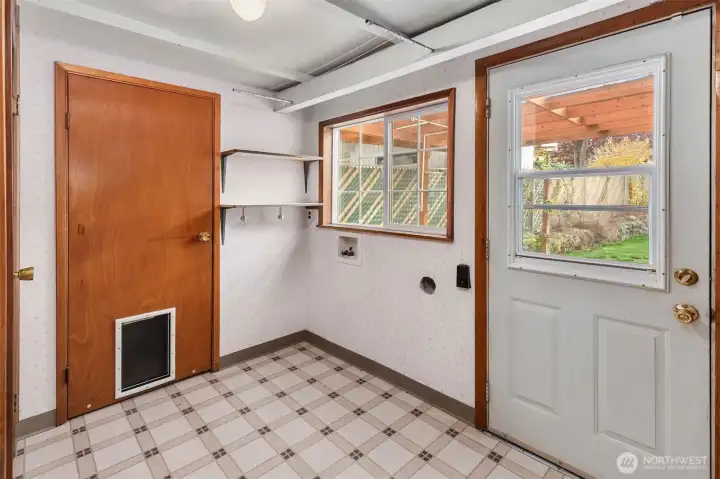 Utility room with laundry hook-ups and access to backyard.
