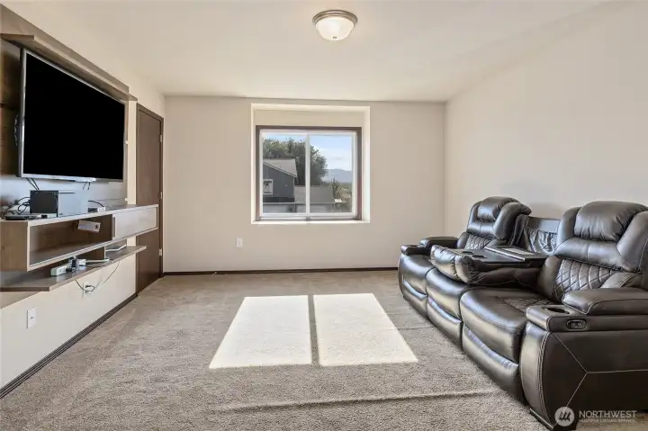 A large bedroom that doubles as the perfect media room —walk-in closet, double doors, and a wall-hung entertainment center ready for your screen time.