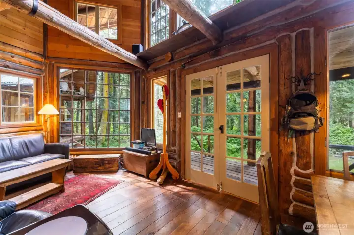 Cabin is filled with windows looking out to the beautiful woods