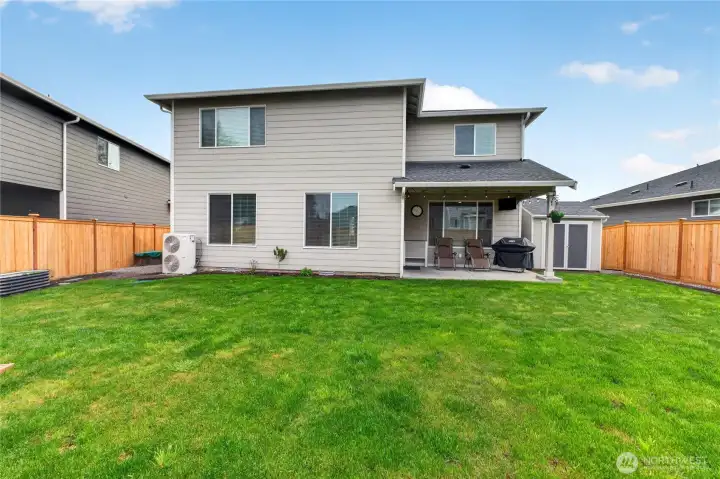 Fully fenced backyard with covered patio, storage shed with power, built in sprinkler for both front and back, paver patio and irrigated vegetable garden.