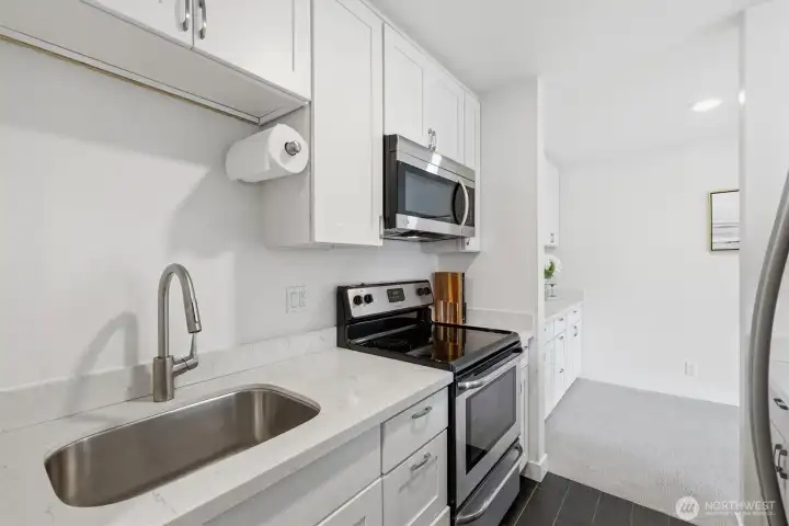 Kitchen showing sink, range and microwave